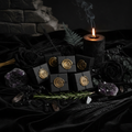 Six dark apothecary boxes with gold crescent moon wax seals on black velvet with crystals and candle