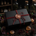 Copper wax sealed box with crescent moon tied with red twine surrounded by wildflowers and citrine