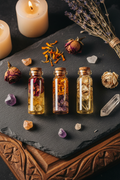 Flat lay of botanical crystal specimen vials on dark slate with dried flowers and raw crystals